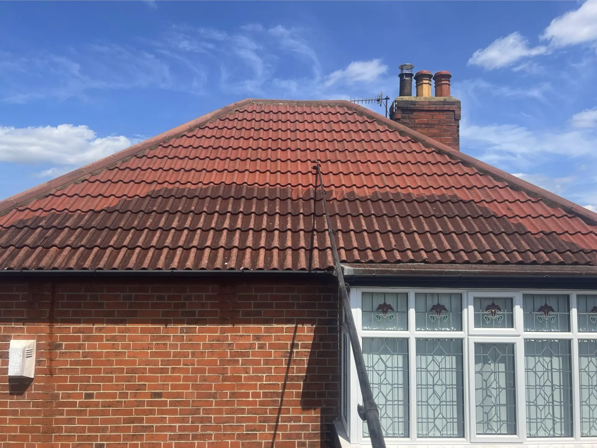 red tiles on roof half-way cleaned